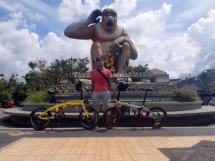 bersepeda di patung bekantan